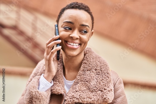 African american woman smiling confident talking on the smartphone at street