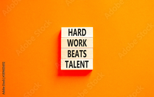 Hard work beats talent symbol. Concept words Hard work beats talent on wooden block. Beautiful orange table orange background. Motivational business hard work beats talent concept. Copy space.