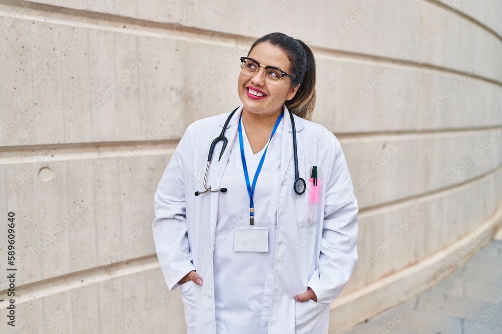 Young beautiful plus size woman doctor smiling confident standing at hospital Young beautiful plus size woman doctor smiling confident standing at hospital