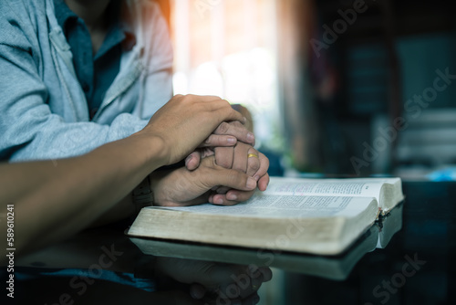 Wife and husband praying on the Bible in their home, faith and trust. Family, worship and praise with married couple man and woman united in prayer, holy or gratitude to Jesus Christ.