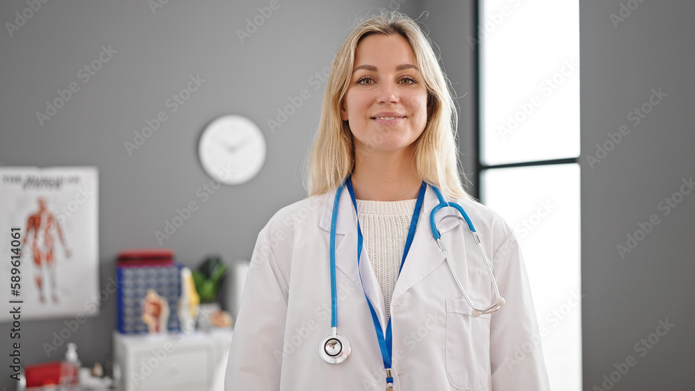 Young blonde woman doctor smiling confident standing at clinic Young blonde woman doctor smiling confident standing at clinic