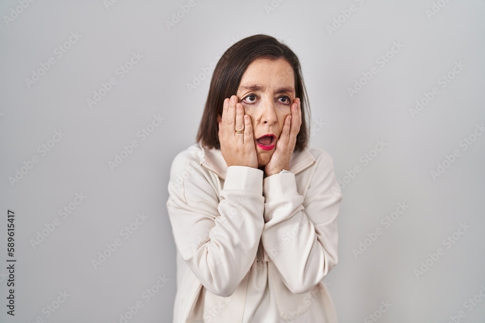 Middle age hispanic woman standing over isolated background tired hands covering face, depression and sadness, upset and irritated for problem Middle age hispanic woman standing over isolated background tired hands covering face, depression and sadness, upset and irritated for problem