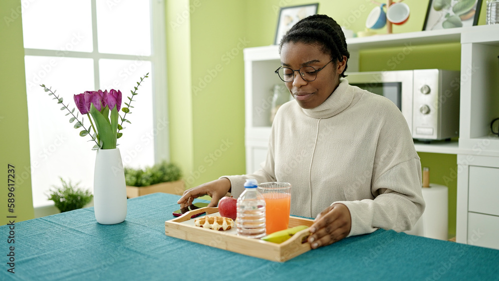 African american woman having breakfast sitting on table at dinning room African american woman having breakfast sitting on table at dinning room