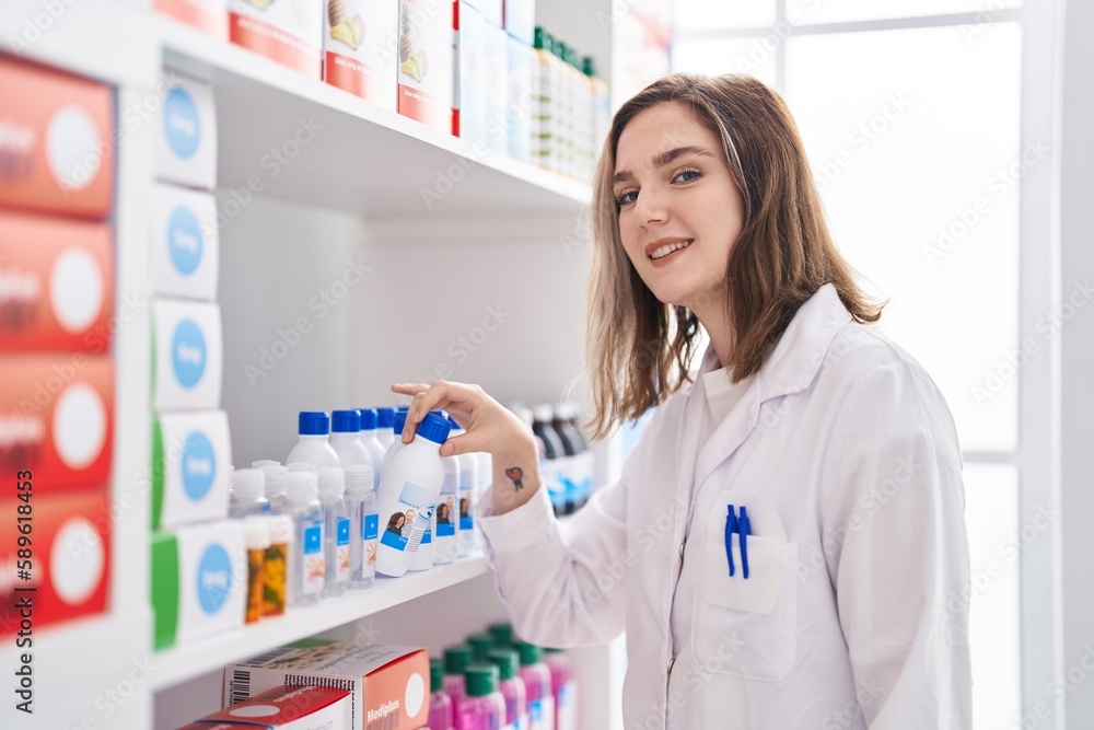 Young woman pharmacist organize shelving at pharmacy