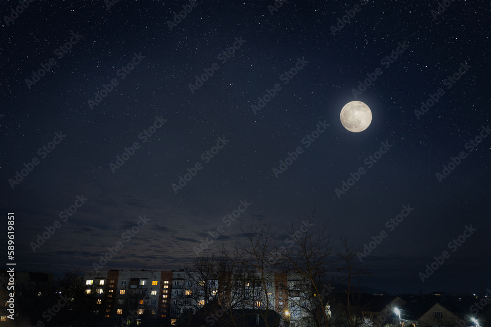 Full moon in dark star sky over town roofs. Full moon in dark star sky over town roofs.