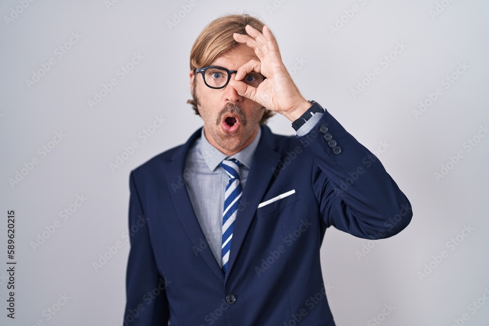 Caucasian man with mustache wearing business clothes doing ok gesture shocked with surprised face, eye looking through fingers. unbelieving expression. Caucasian man with mustache wearing business clothes doing ok gesture shocked with surprised face, eye looking through fingers. unbelieving expression.