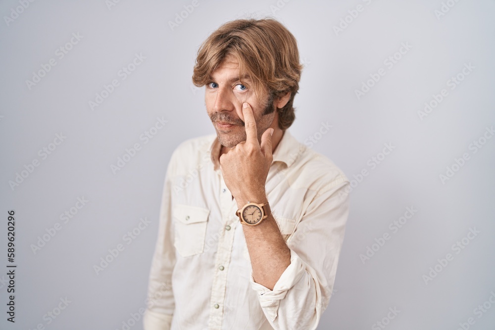 Middle age man standing over isolated background pointing to the eye watching you gesture, suspicious expression Middle age man standing over isolated background pointing to the eye watching you gesture, suspicious expression
