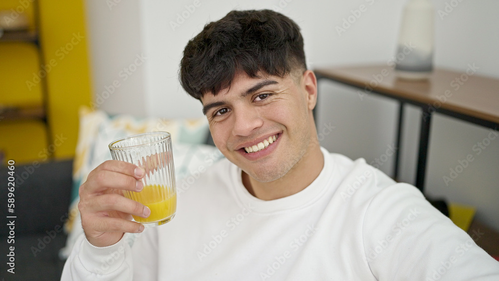 Young hispanic man smiling confident holding glass of juice at home Young hispanic man smiling confident holding glass of juice at home