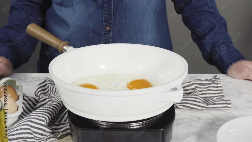 Frying farm fresh eggs in a white skillet. Frying farm fresh eggs in a white skillet.
