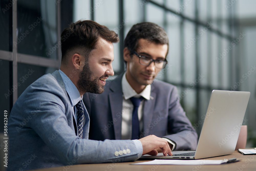 Fototapeta premium Two handsome businessmen working together on a project sitting