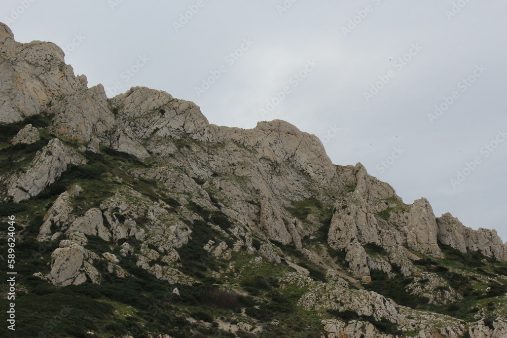 Calanques National Park - Rocky mountainous outcrops in spring as seen from the water on an overcast day. Island of île Maïre off the coast of Marseille