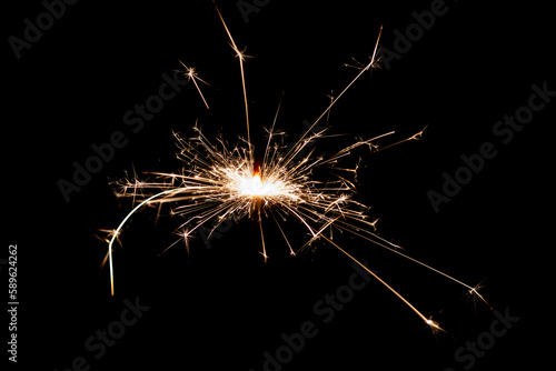 Burning sparkler isolated on black background. Fireworks theme. Light effect and texture.