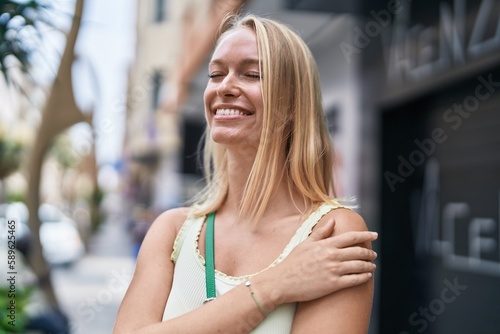 Free Download Young blonde woman smiling confident looking to the side at street - GFXLoad