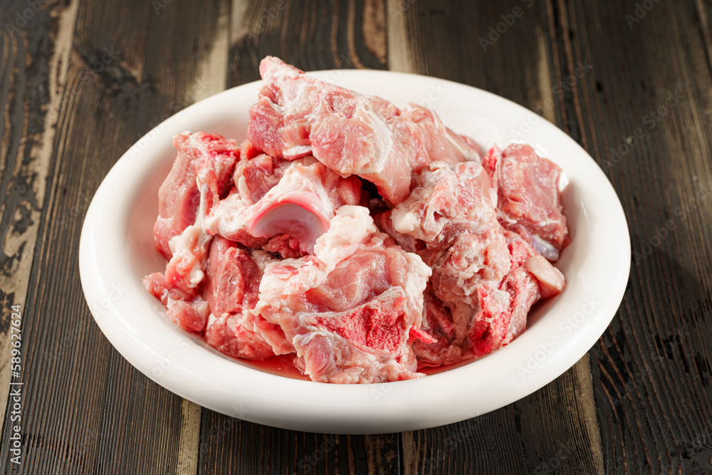 Fresh pork spine in a white porcelain plate Fresh pork spine in a white porcelain plate