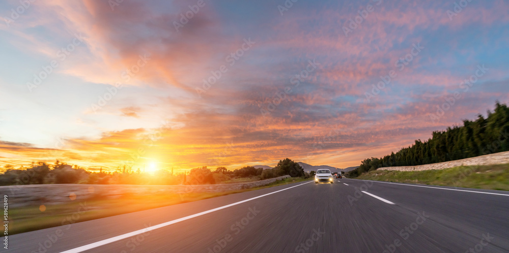 Mediterranean sea coast road into mountains horizon in summer with beautiful bright sun rays. long exposure high speed motion blur shot
