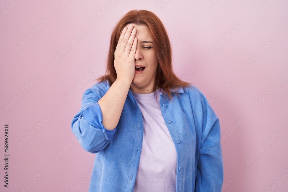 Young hispanic woman with red hair standing over pink background yawning tired covering half face, eye and mouth with hand. face hurts in pain. Young hispanic woman with red hair standing over pink background yawning tired covering half face, eye and mouth with hand. face hurts in pain.