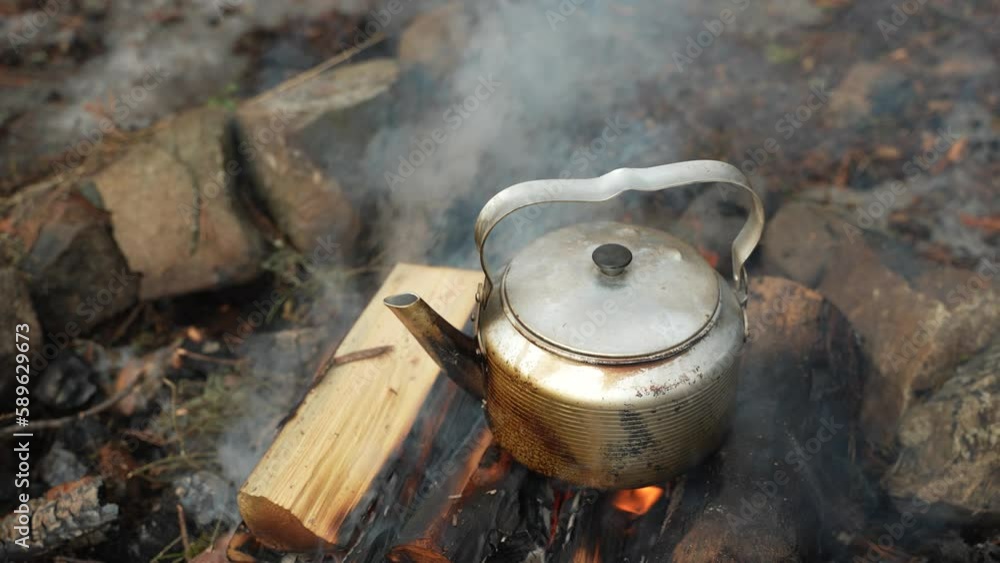 Coffee in a kettle on campfire in forest. Travel and camping concept. Coffee in a kettle on campfire in forest. Travel and camping concept.
