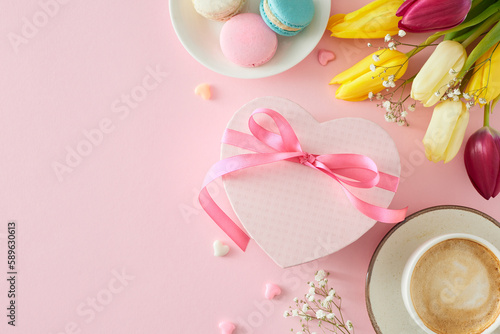 Mother's Day concept. Top view photo of heart shaped giftbox cup of coffee macaroons small hearts bunch of colorful tulips and gypsophila flowers on pastel pink background with blank space
