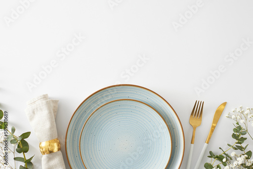 Table setting concept. Flat lay photo of empty plate cutlery knife fork fabric napkin with ring eucalyptus leaves and gypsophila flowers on white background with copyspace