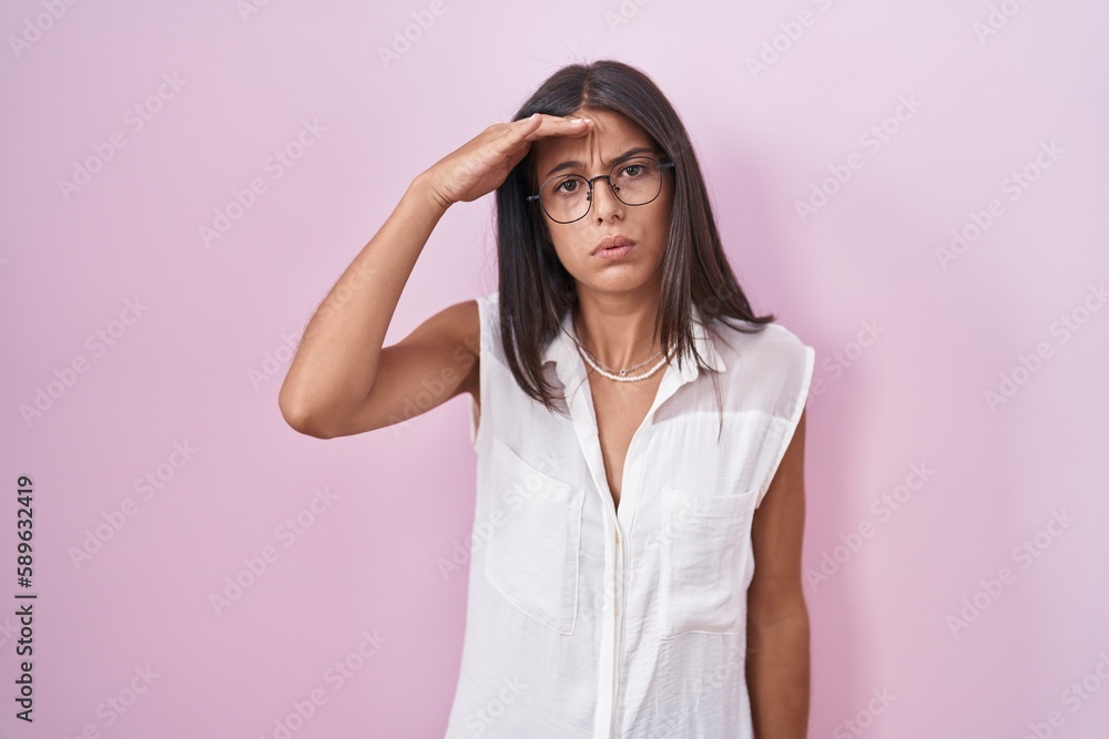 Brunette young woman standing over pink background wearing glasses worried and stressed about a problem with hand on forehead, nervous and anxious for crisis Brunette young woman standing over pink background wearing glasses worried and stressed about a problem with hand on forehead, nervous and anxious for crisis