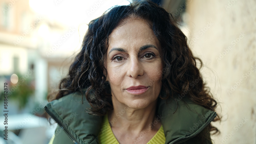 Obraz premium Middle age hispanic woman standing with relaxed expression at street