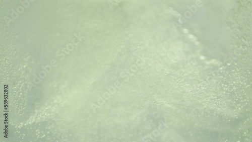 Lemon soda being poured in a glass. Yellow sparkling water.
