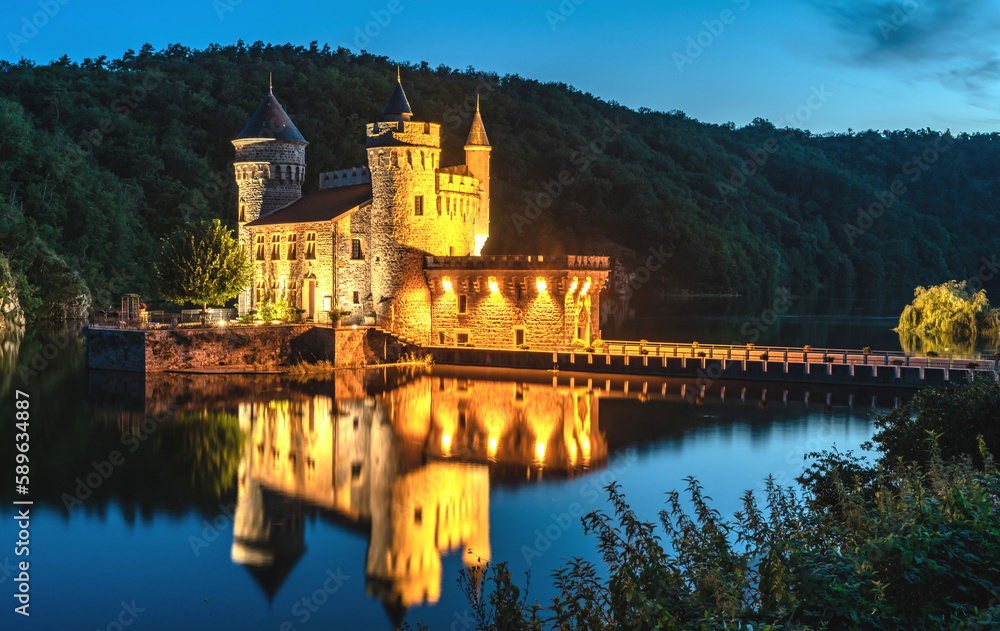 Un château dans la Loire éclairé au bord d'un lac à l'heure bleue