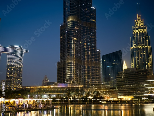 Downtown Dubai at sunset, skyscrapers with light in the windows, the reflection of Burj Khalifa in the waters of the lake