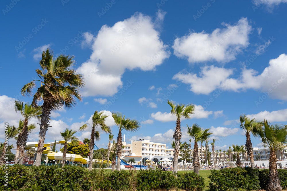 Windy day over the hotels of the Mediterranean resort town, palm branches fluttering in the wind