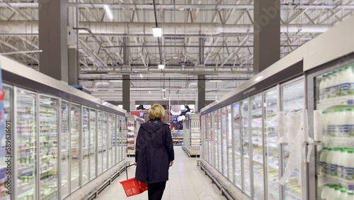 Wallpaper Mural  Man choosing frozen food from a supermarket freezer., reading product information Torontodigital.ca