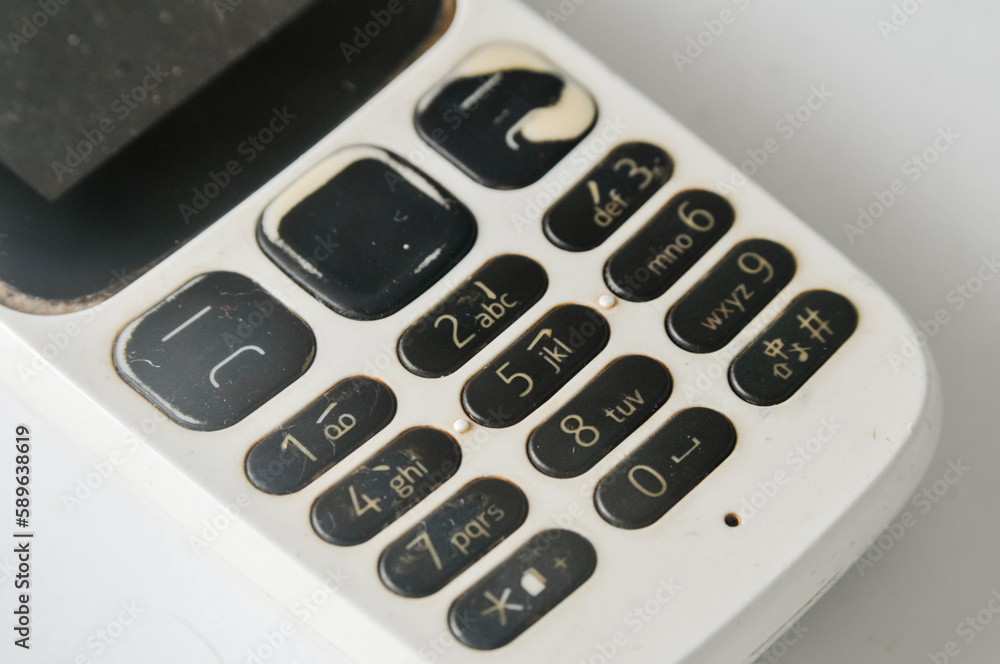 keypad of an old GSM mobile phone looks worn out in several places keypad of an old GSM mobile phone looks worn out in several places