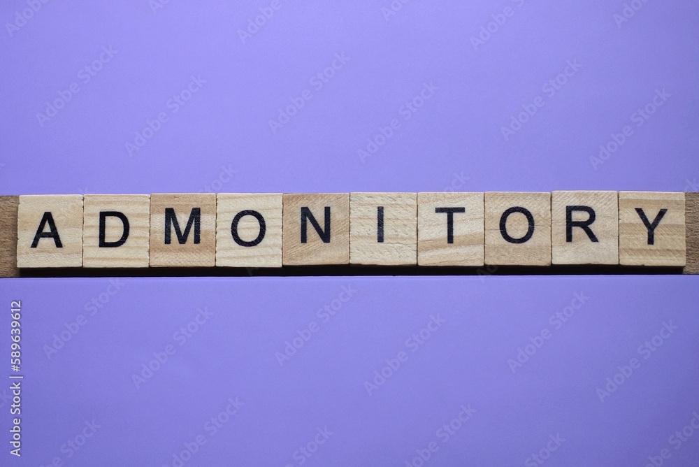 word admonitory made from wooden gray letters lies on a lilac background word admonitory made from wooden gray letters lies on a lilac background