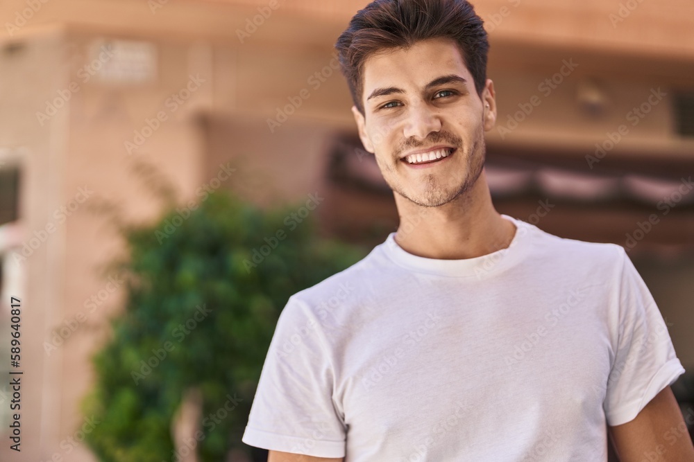 Young hispanic man smiling confident standing at park