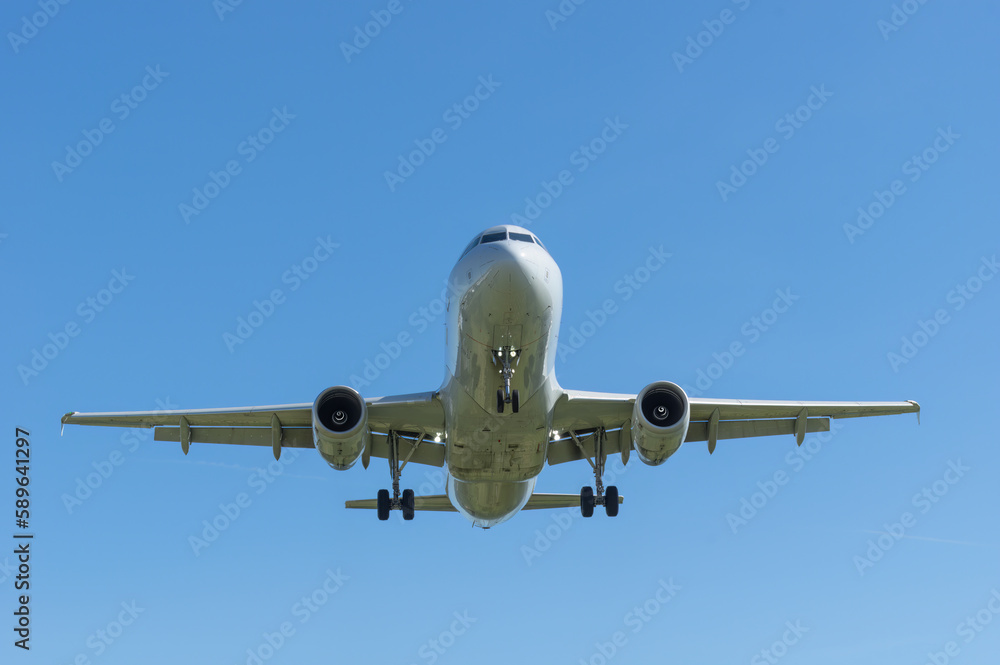 Modern passenger jet shown approaching for landing shown against a blue sky. Modern passenger jet shown approaching for landing shown against a blue sky.