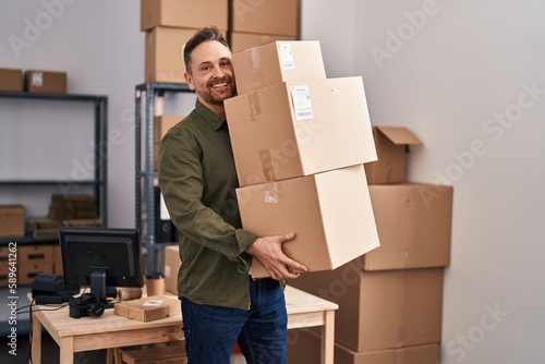 Young caucasian man ecommerce business worker holding packages at office