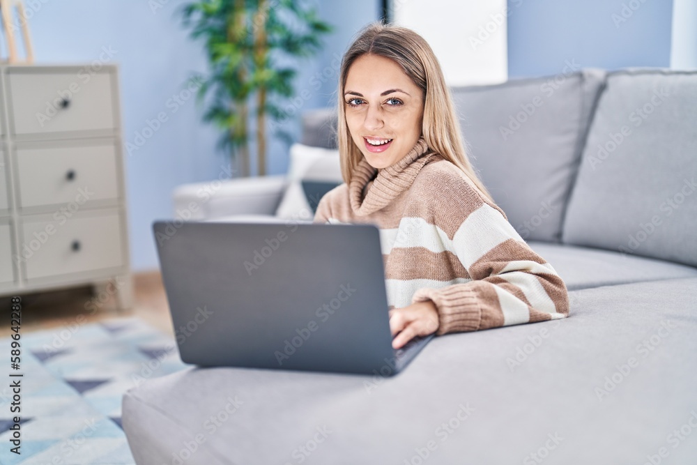 Young woman using laptop sitting on floor at home Young woman using laptop sitting on floor at home