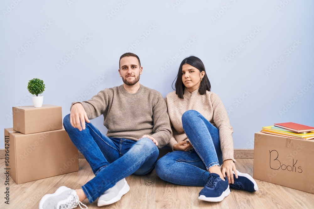 Young couple moving to a new home relaxed with serious expression on face. simple and natural looking at the camera. Young couple moving to a new home relaxed with serious expression on face. simple and natural looking at the camera.