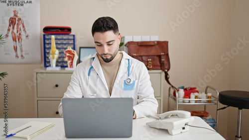 Wallpaper Mural Young arab man doctor using laptop working at clinic Torontodigital.ca