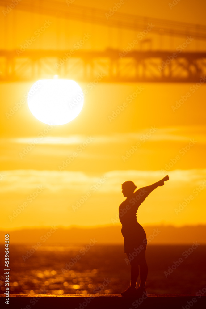 A sporty man stretching out on the waterfront at sunset A sporty man stretching out on the waterfront at sunset