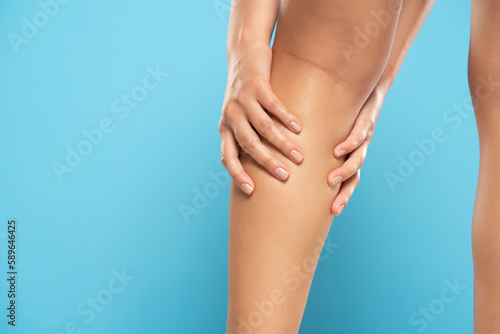 Woman have a calf leg pain and muscle leg pain, Healthcare concept on a blue background