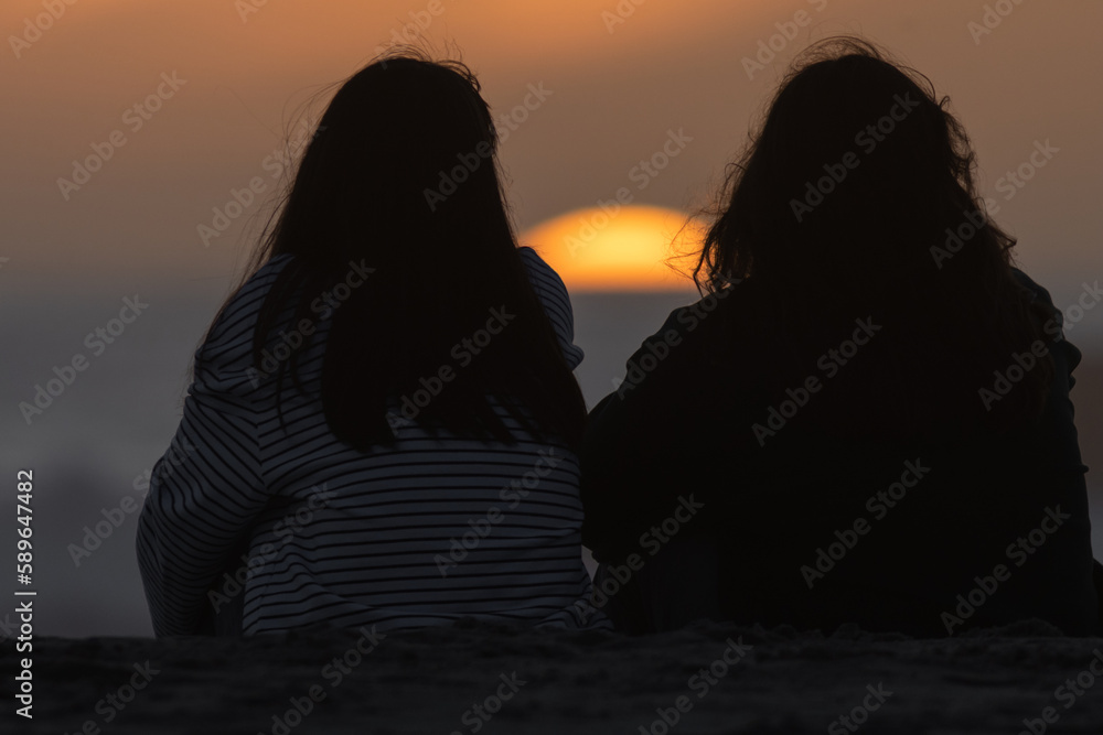 Two girls sitting and watching the sunset