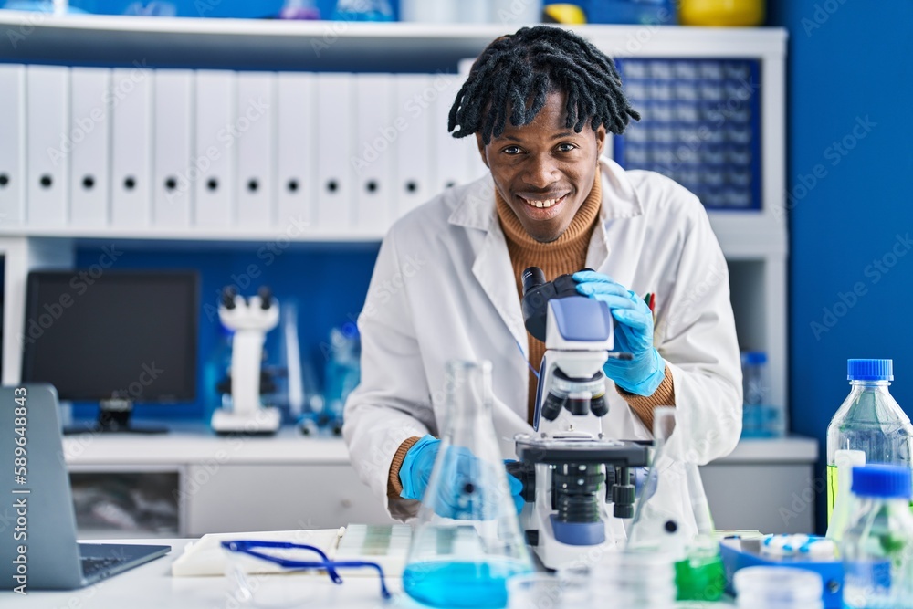 African american man scientist using microscope at laboratory