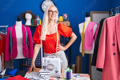 Young blonde woman tailor smiling confident standing at sewing studio photo