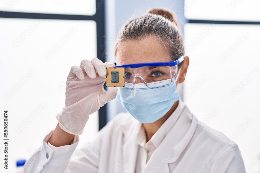 Young woman scientist holding cpu processor at laboratory Young woman scientist holding cpu processor at laboratory