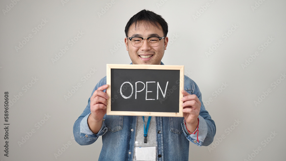 Young chinese man smiling confident holding open blackboard over isolated white background Young chinese man smiling confident holding open blackboard over isolated white background