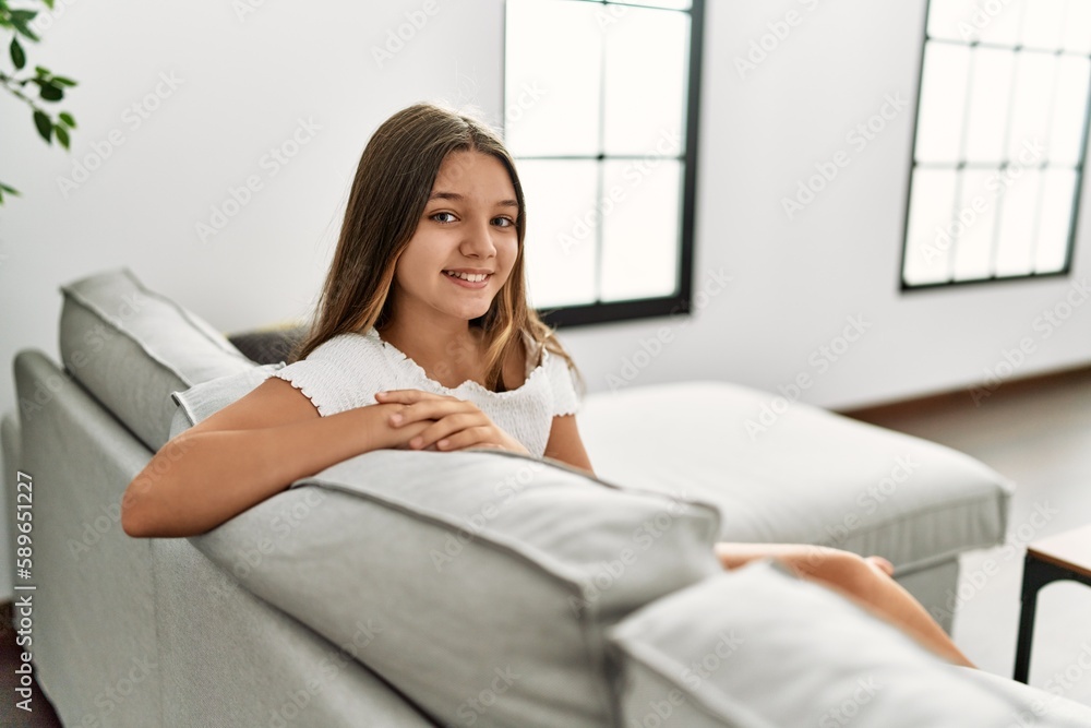 Adorable girl smiling confident sitting on sofa at home Adorable girl smiling confident sitting on sofa at home