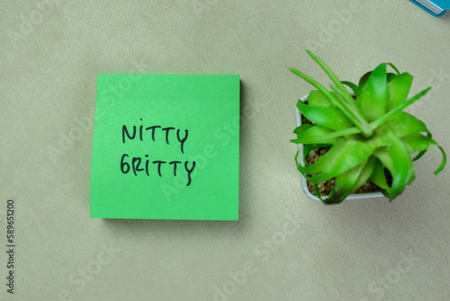 Concept of Nitty Gritty write on sticky notes isolated on Wooden Table. photo
