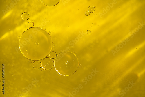 Close-up of liquid golden oil, serum with bubbles as texture or background