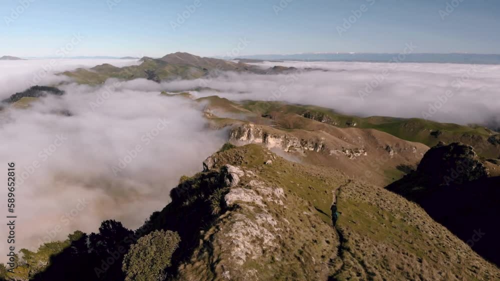 Aerial view of couple walking on Te Mata Park on a landscape full of clouds. Aerial view of couple walking on Te Mata Park on a landscape full of clouds.