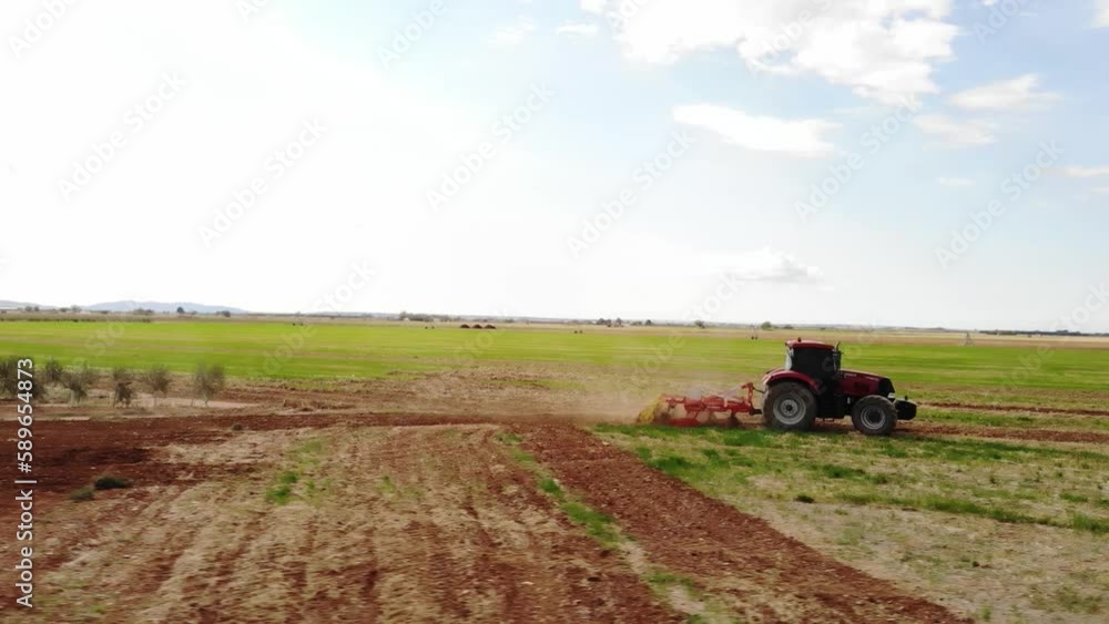 Red tractor working on the field in Spain making tillage Red tractor working on the field in Spain making tillage